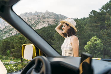 Woman wearing hat seen from van windshield - DAMF00962