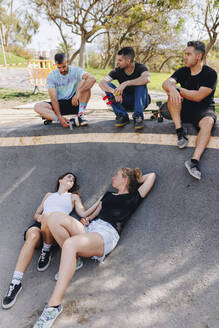 Freunde machen Pause und entspannen sich im Skateboardpark - MRRF02177