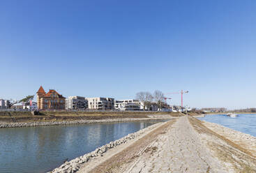 Deutschland, Rheinland-Pfalz, Speyer, Klarer Himmel über dem Rhein mit Neubaugebiet im Hintergrund - GWF07419