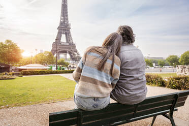 Älteres Paar sitzt zusammen auf einer Bank im Park und bewundert den Eiffelturm, Paris, Frankreich - OIPF01830