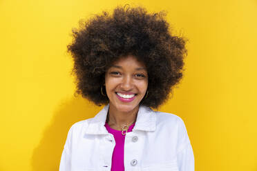 Smiling Afro woman in front of yellow wall - OIPF01857