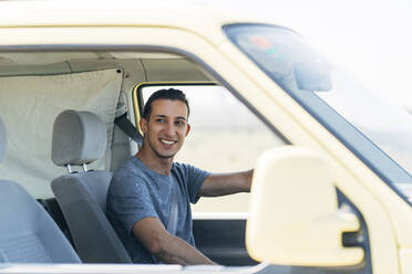 Lächelnder junger Mann am Steuer eines Lieferwagens - DAMF00966