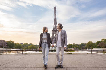 Glückliches reifes Paar, das sich an den Händen hält, vor dem Eiffelturm, Paris, Frankreich - OIPF01897