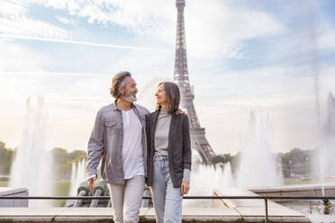 Lächelnder reifer Mann und lächelnde Frau schauen sich vor dem Eiffelturm an, Paris, Frankreich - OIPF01901