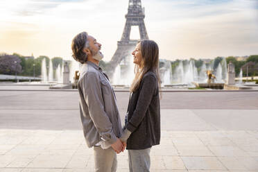 Glückliches reifes Paar, das sich an den Händen hält, vor dem Eiffelturm, Paris, Frankreich - OIPF01903
