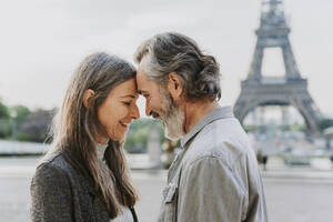 Glückliches reifes Paar, das sich vor dem Eiffelturm die Stirn berührt, Paris, Frankreich - OIPF01906