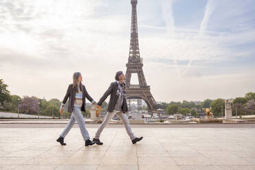 Älteres Paar hält sich an den Händen und geht vor dem Eiffelturm, Paris, Frankreich - OIPF01917