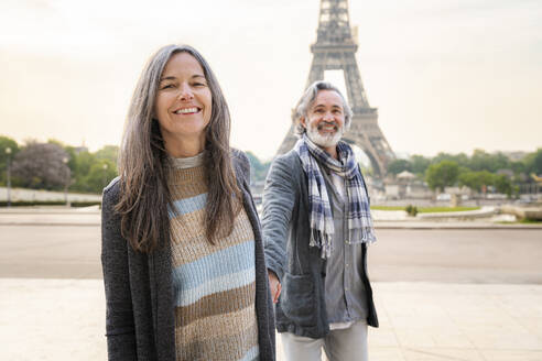 Glückliche reife Frau mit Mann vor dem Eiffelturm, Paris, Frankreich an einem sonnigen Tag - OIPF01922