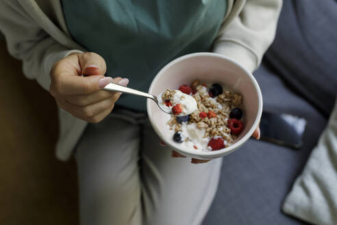 Woman holding bowl of yogurt and muesli - TYF00198