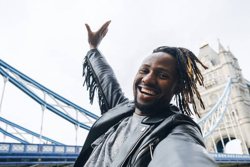 Fröhlicher Mann mit Dreadlocks macht Selfie, London, England - ASGF02354