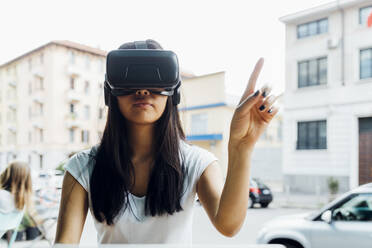 Eine junge Frau nutzt Gesten im Virtual-Reality-Simulator - MEUF05933