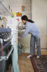 Side view of girl working in kitchen at home - MASF30378