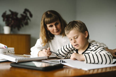 Mutter unterrichtet behinderten Sohn während des Hausunterrichts zu Hause - MASF30401