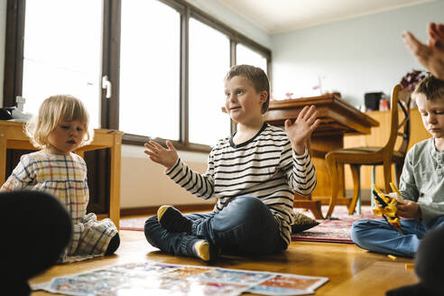 Junge mit Down-Syndrom vervollständigt Puzzle, während er mit seiner Familie im Wohnzimmer sitzt - MASF30416
