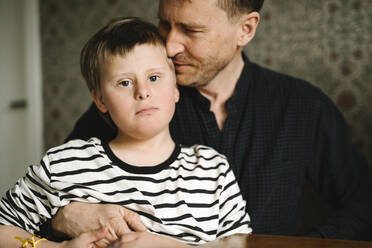 Portrait of boy having down syndrome with father at home - MASF30429