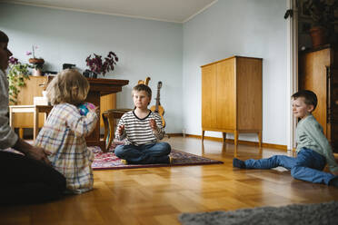 Siblings playing with ball in living room at home - MASF30434