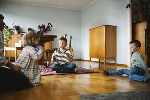 Geschwister spielen mit Ball im Wohnzimmer zu Hause - MASF30434