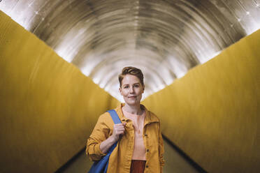 Porträt einer selbstbewussten reifen Frau mit Tasche, die in einem U-Bahn-Tunnel steht - MASF30490