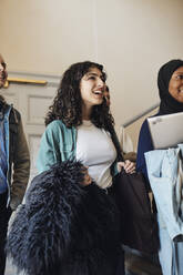 Lächelnde Studentin mit Freunden in der Universität - MASF30759