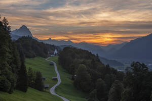 Deutschland, Bayern, Wamberg, Straße zu einem abgelegenen Dorf im Wettersteingebirge in der Abenddämmerung - RUEF03685