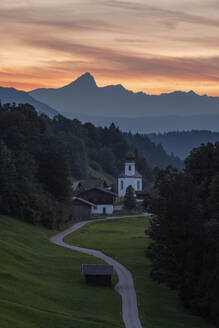 Deutschland, Bayern, Wamberg, Straße zu einem abgelegenen Dorf im Wettersteingebirge in der Abenddämmerung - RUEF03686