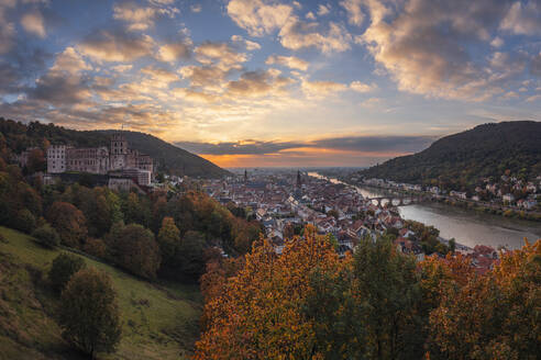 Germany, Baden-Wurttemberg, Heidelberg, Heidelberg Castle and surrounding town at autumn sunset - RUEF03701