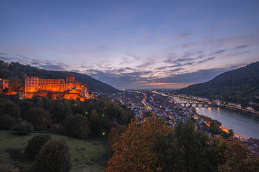 Deutschland, Baden-Württemberg, Heidelberg, Blick auf das Heidelberger Schloss und die umliegende Stadt in der Abenddämmerung - RUEF03702