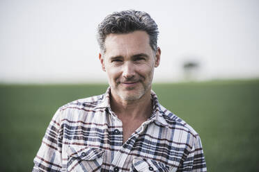 Smiling mature man wearing plaid shirt - UUF26332