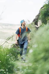 Abenteuerlustiger Mann beim Wandern auf einem Berg - DAMF00983