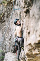 Mann ohne Hemd klettert am Wochenende auf Felsen - DAMF00986