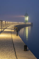 Deutschland, Schleswig-Holstein, Lübeck, Travemünder Leuchtturm bei nebliger Nacht - KEBF02301