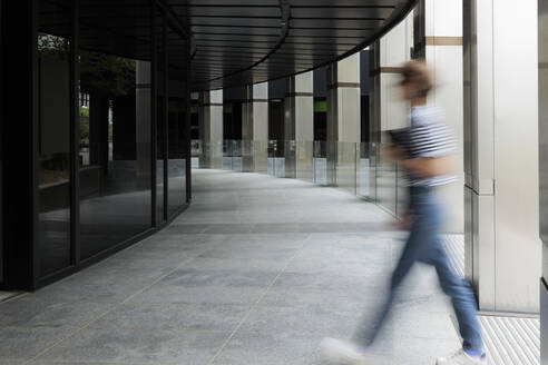 Blurred motion of woman entering in building - MRRF02236