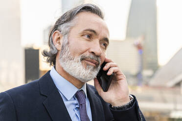 Älterer Geschäftsmann im Gespräch mit einem Smartphone - OIPF02038