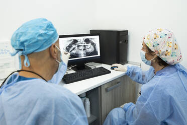 Dentists analyzing x-ray on computer screen at clinic - MMPF00062