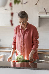 Woman with vegetables in kitchen at home - LLUF00549