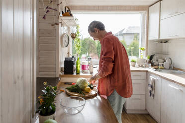 Woman with vegetables in kitchen at home - LLUF00550