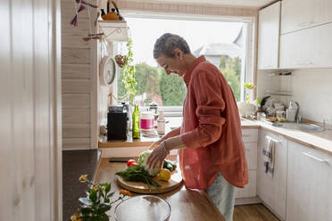 Woman with vegetables in kitchen at home - LLUF00551