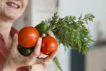 Lächelnde Frau mit Tomaten, Gurken und Dill - LLUF00553