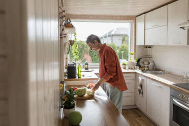 Woman preparing salad in kitchen at home - LLUF00565