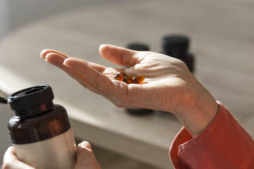 Close-up of woman holding pills - LLUF00584