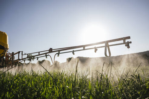 Crop sprayer spraying fertilizer on field on sunny day - JCMF02280