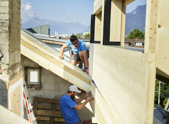 Arbeiter bei Bauarbeiten auf dem Dach eines Hauses - CVF01976