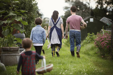 Familie spaziert im Hinterhof Garten Gras - CAIF32781