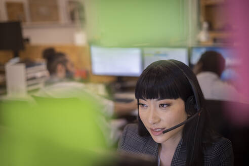 Geschäftsfrau mit Headset bei der Arbeit im Büro - CAIF32816