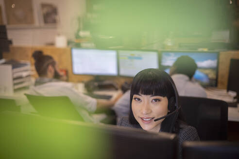 Porträt einer lächelnden Geschäftsfrau mit Headset im Büro - CAIF32824