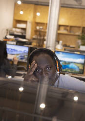 Konzentrierter Geschäftsmann mit Headset bei der Arbeit im Büro - CAIF32842