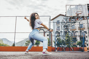 Frau tanzt auf Basketballplatz - OMIF00888