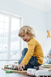 Boy playing with toy train at home - VPIF06260