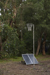 Sonnenkollektoren unter dem Basketballkorb zwischen Bäumen - FSIF05967