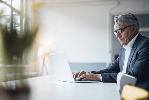 Älterer Geschäftsmann arbeitet am Laptop am Schreibtisch - JOSEF10226